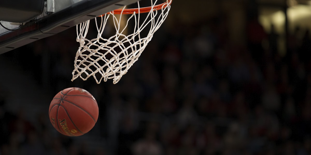 NBA篮球比赛精彩瞬间，球员高高跃起准备扣篮